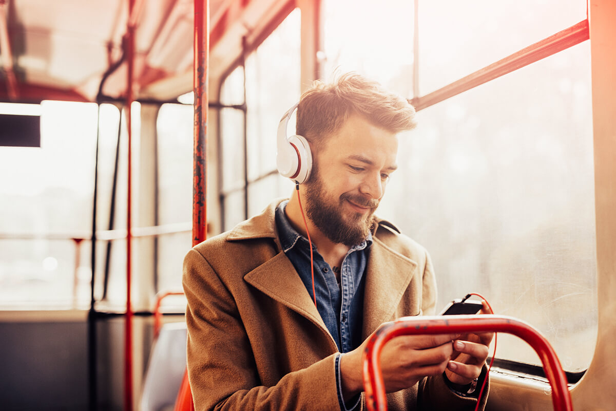 Homme dans un bus écoutant de la musique sur son téléphone
